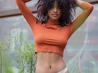 Curly haired teenager Barbie flaunts her extraordinaire rump while unwrapping outdoors