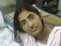 Indian lady takes selfies in a mirror while wearing a watch-thru tank top