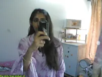 Indian lady takes selfies in a mirror while wearing a watch-thru tank top