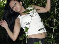 Pretty Indian chick suspends from a tree limb in a tank top and cut-offs
