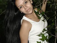 Pretty Indian chick suspends from a tree limb in a tank top and cut-offs