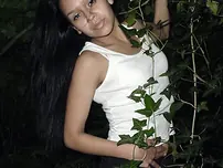 Pretty Indian chick suspends from a tree limb in a tank top and cut-offs