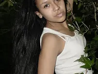 Pretty Indian chick suspends from a tree limb in a tank top and cut-offs