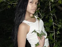 Pretty Indian chick suspends from a tree limb in a tank top and cut-offs